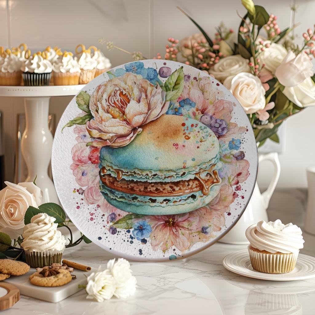 Round glass cutting board featuring a watercolor-style macaron surrounded by soft pastel flowers. Elegant kitchen decor, ideal as a dessert-themed gift.