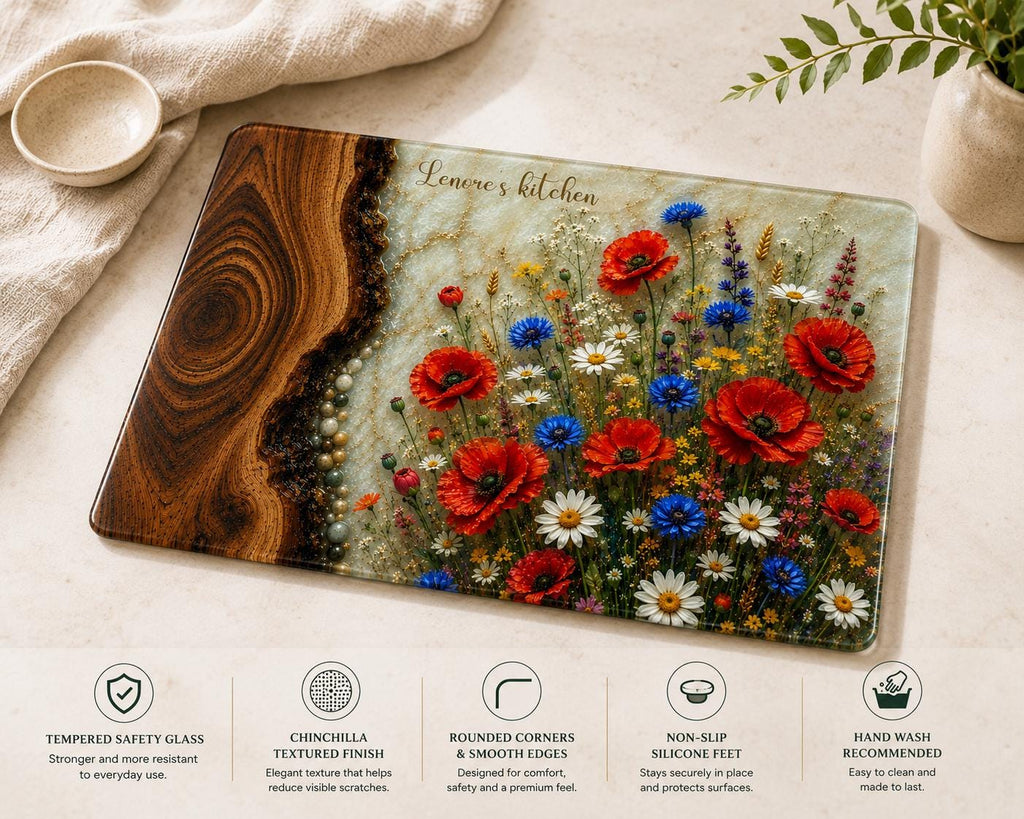 Personalised reinforced glass cutting board with epoxy resin style wood and wildflower design, 'Lenore's kitchen' text, and polished edges, displayed on a light kitchen countertop.