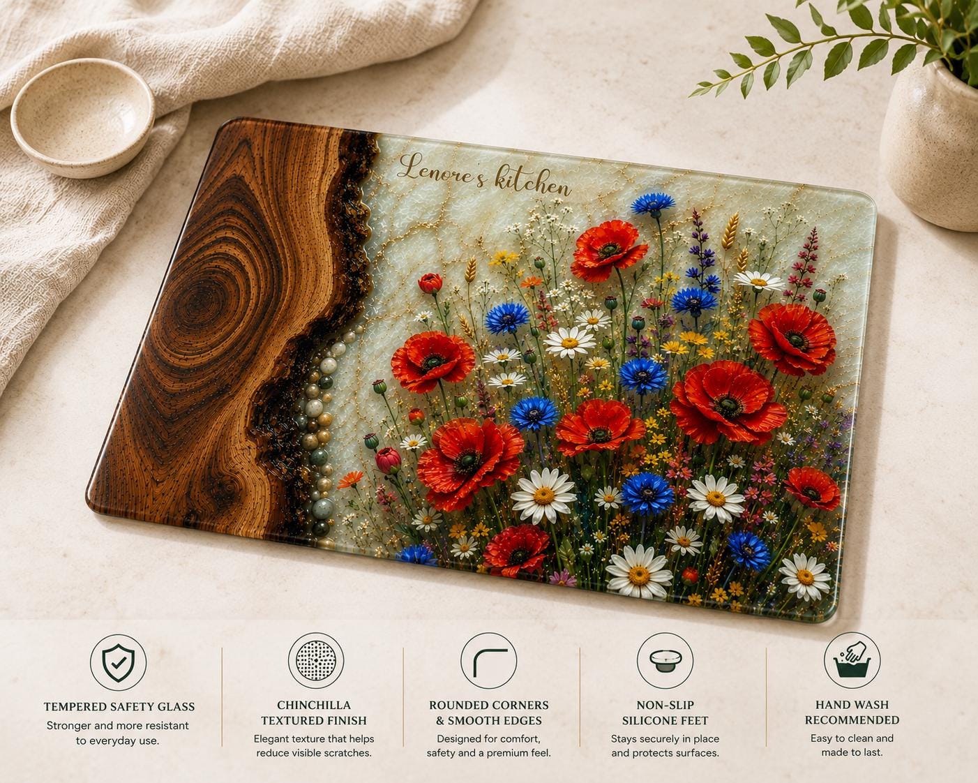 Personalised reinforced glass cutting board with epoxy resin style wood and wildflower design, 'Lenore's kitchen' text, and polished edges, displayed on a light kitchen countertop.