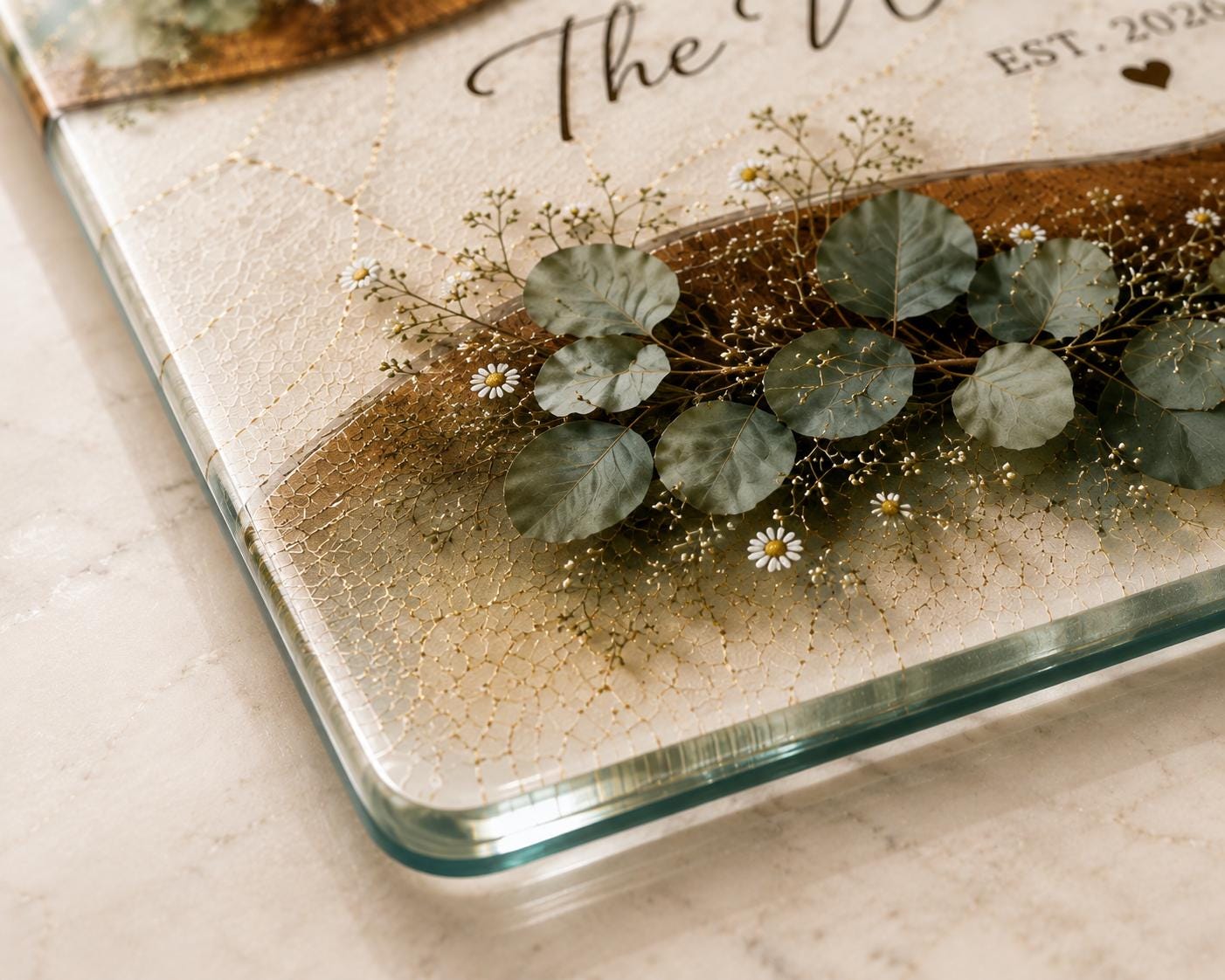 Botanical glass cutting board featuring white daisies, eucalyptus greenery, and personalized established year.