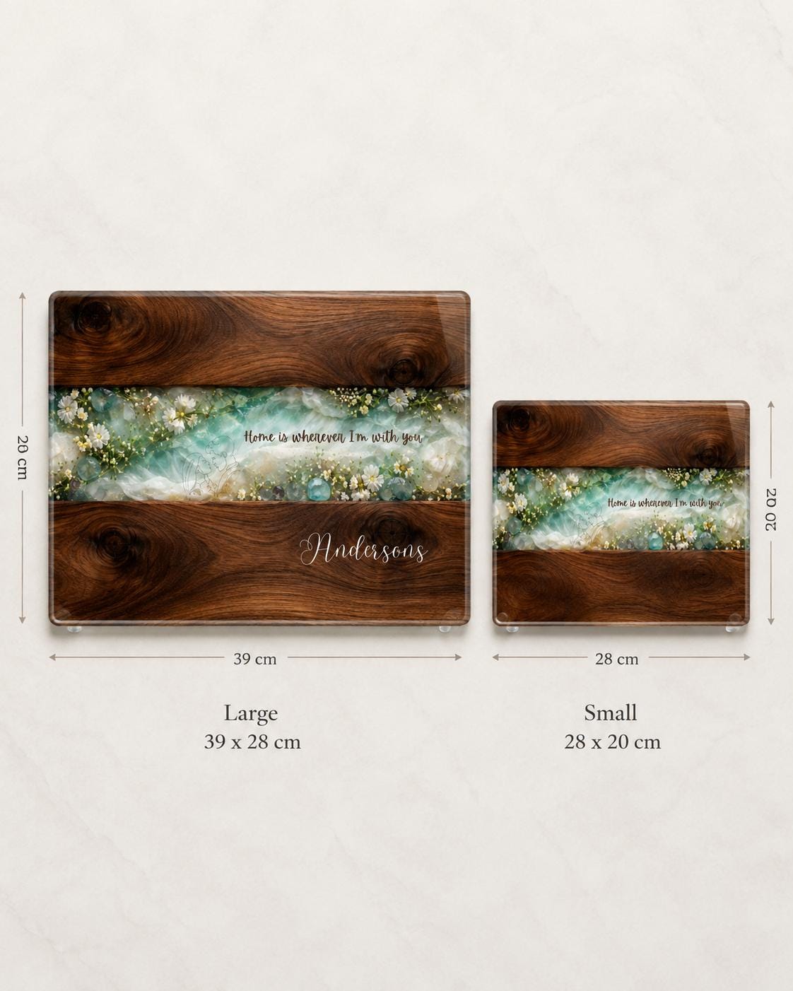 Personalised glass chopping board size comparison showing large 39 x 28 cm and small 28 x 20 cm boards with dark wood effect, turquoise floral resin-style design and custom family name.